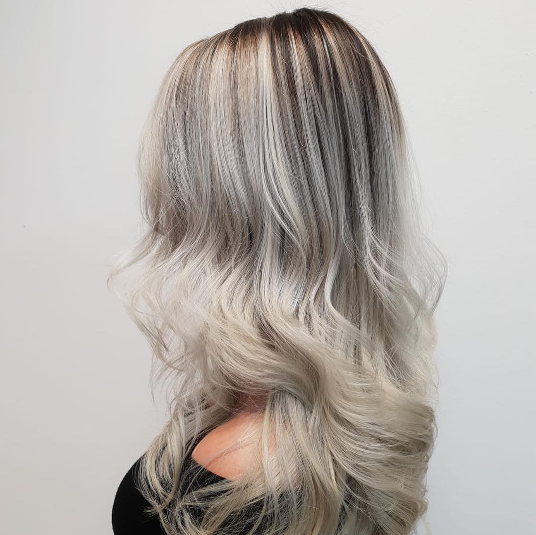 Zilverblond haar met een donkere aanzet, in golven