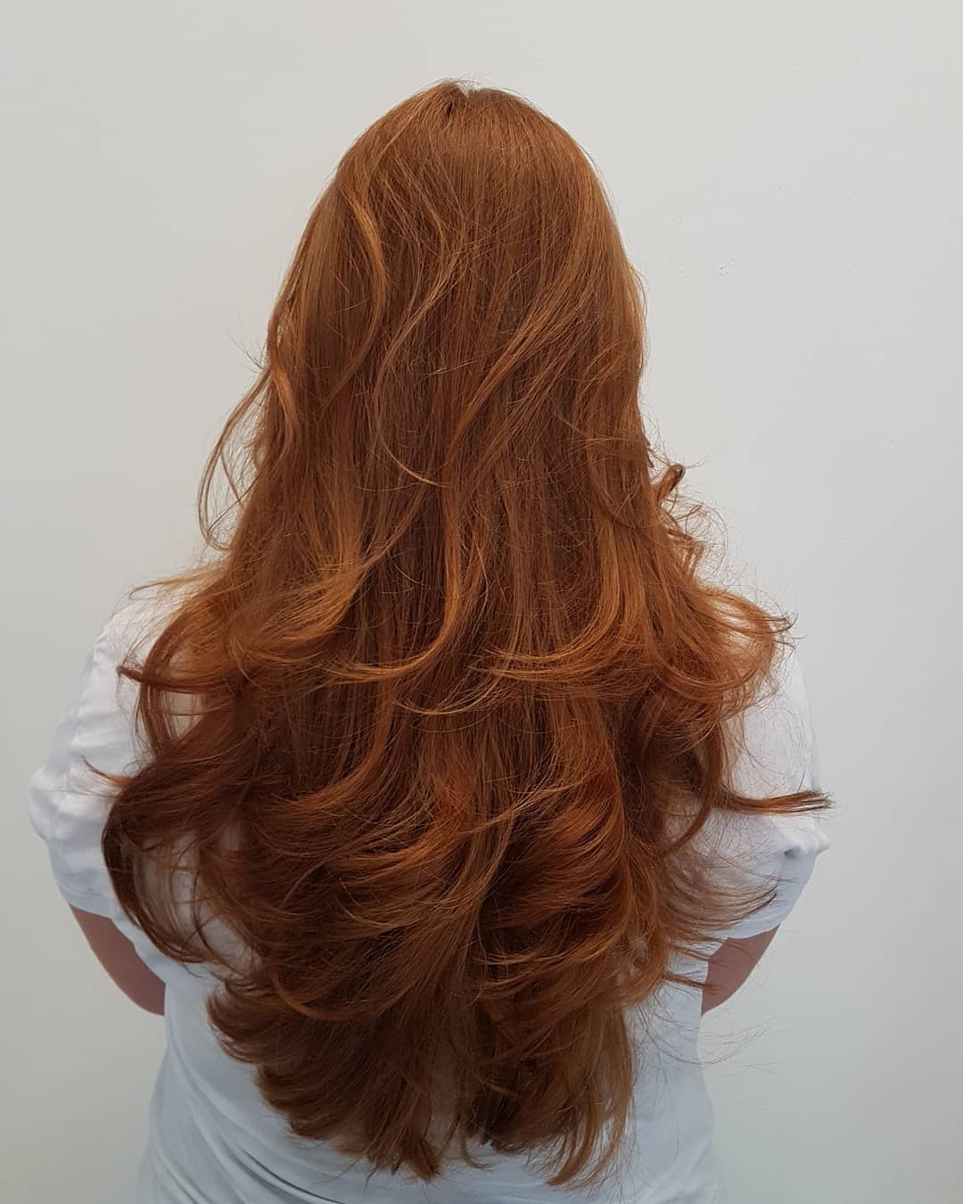 Lang koperrood haar in laagjes, van achteren