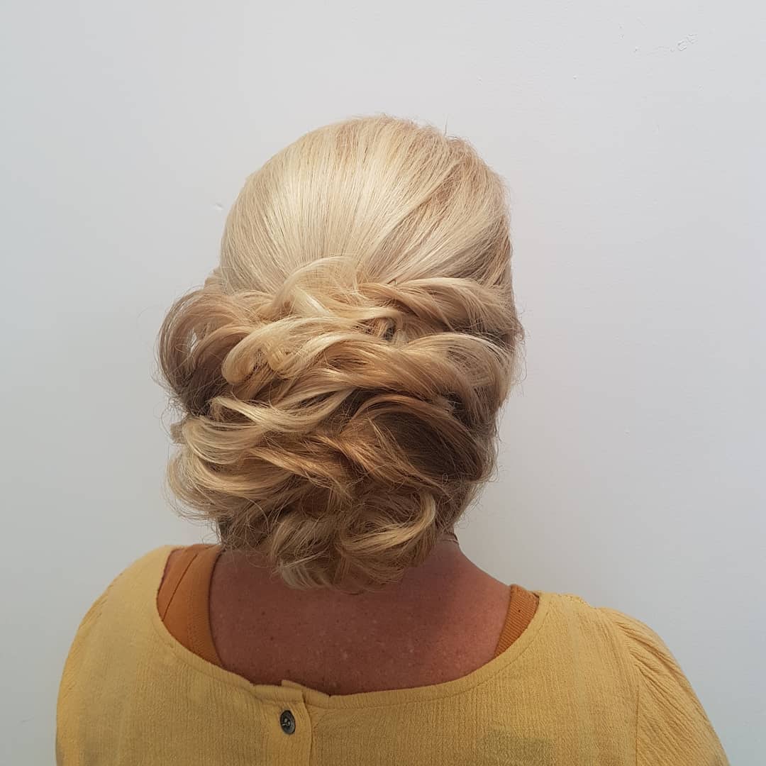 Opgestoken blond haar met losse krullen, van achteren